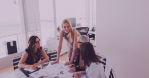 An image of four women smiling and working together.